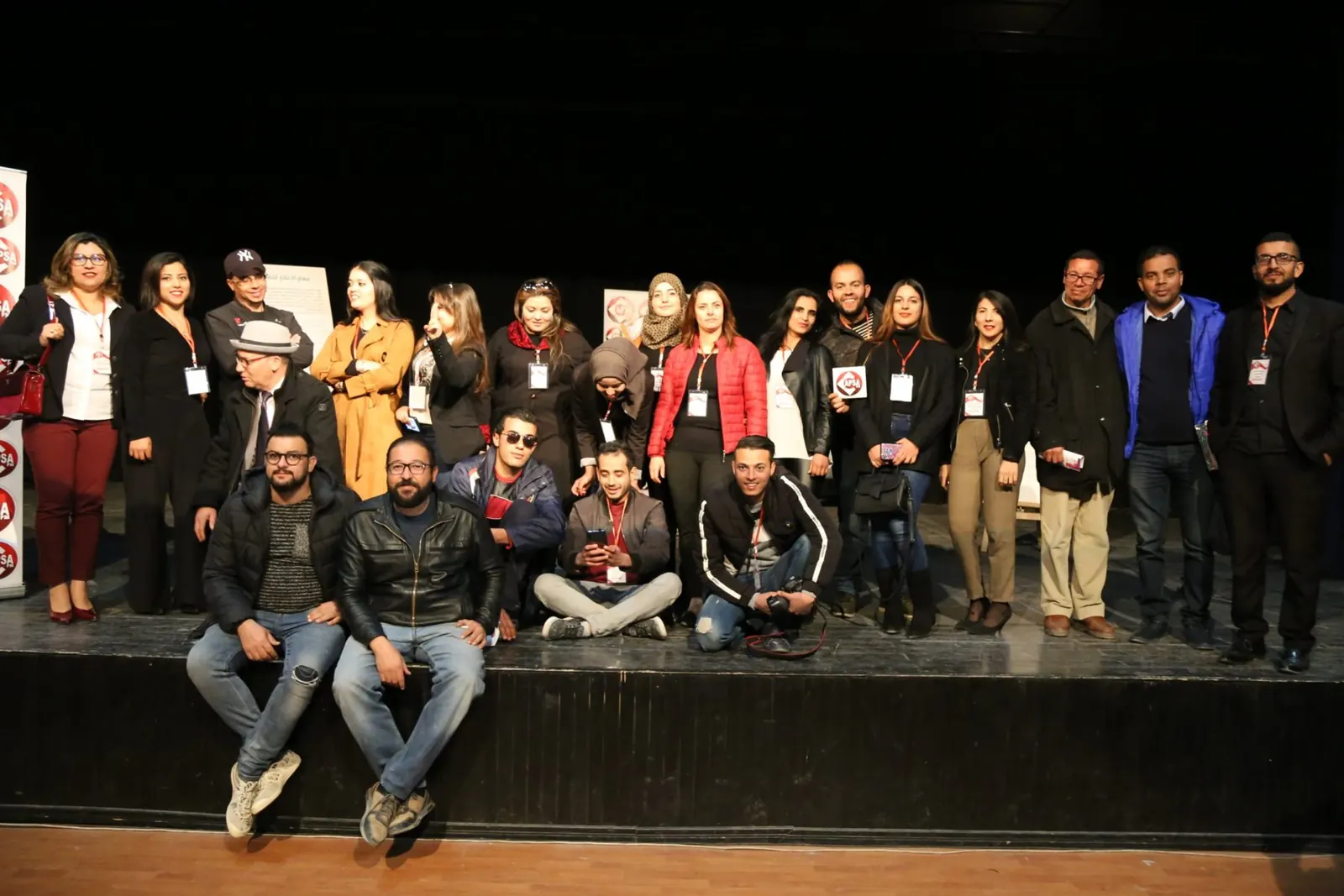Group on stage during a Radio Capsa FM event, in front of the station's banners